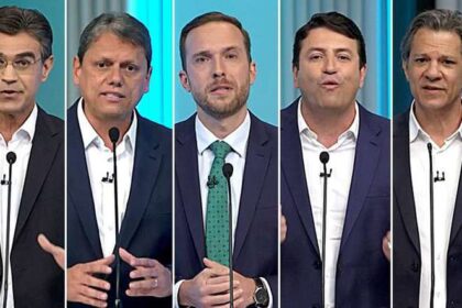 Eleitor indeciso diante de urna eletrônica com números de candidatos para governador de SP