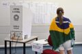 Urna eletrônica brasileira com tela acesa em local de votação, símbolo da democracia digital