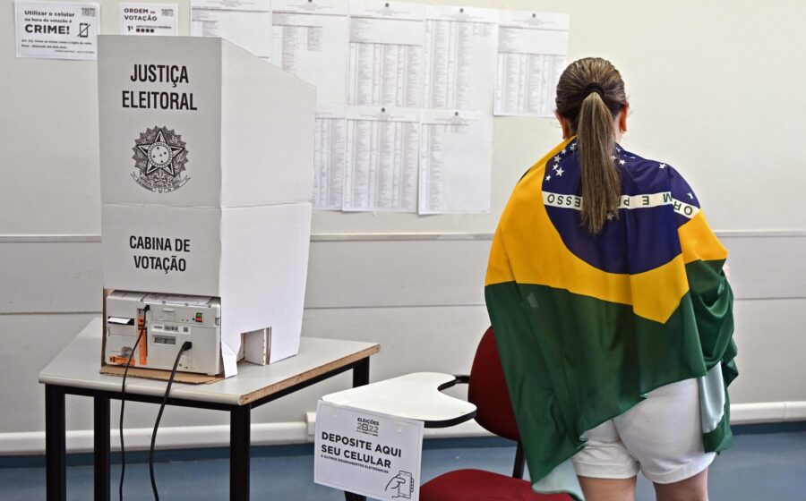Urna eletrônica brasileira com tela acesa em local de votação, símbolo da democracia digital