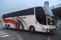 Ônibus interestaduais parados em terminal com prédio da ANTT ao fundo simbolizando burocracia travada