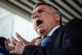 Jair Bolsonaro discursa para apoiadores com gesto de punho cerrado, simbolizando narrativa de perseguição política