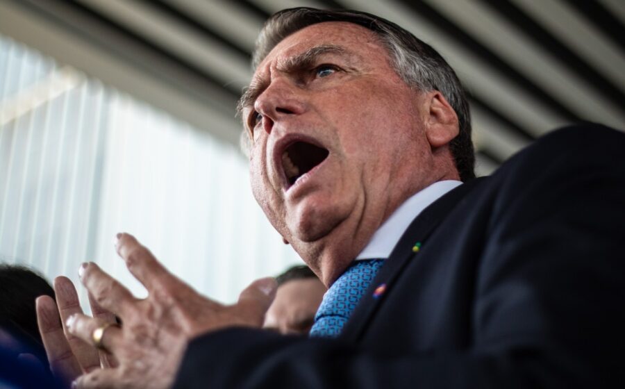Jair Bolsonaro discursa para apoiadores com gesto de punho cerrado, simbolizando narrativa de perseguição política