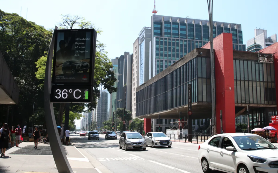 Brasília sob calor extremo: asfalto quente, trânsito parado e Monumento aos Candangos ao fundo