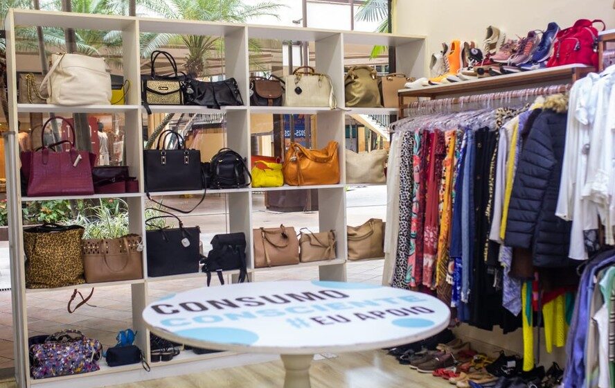 Multidão em brechó de grife Desapega CG em Campo Grande com araras de moda luxo a preços populares