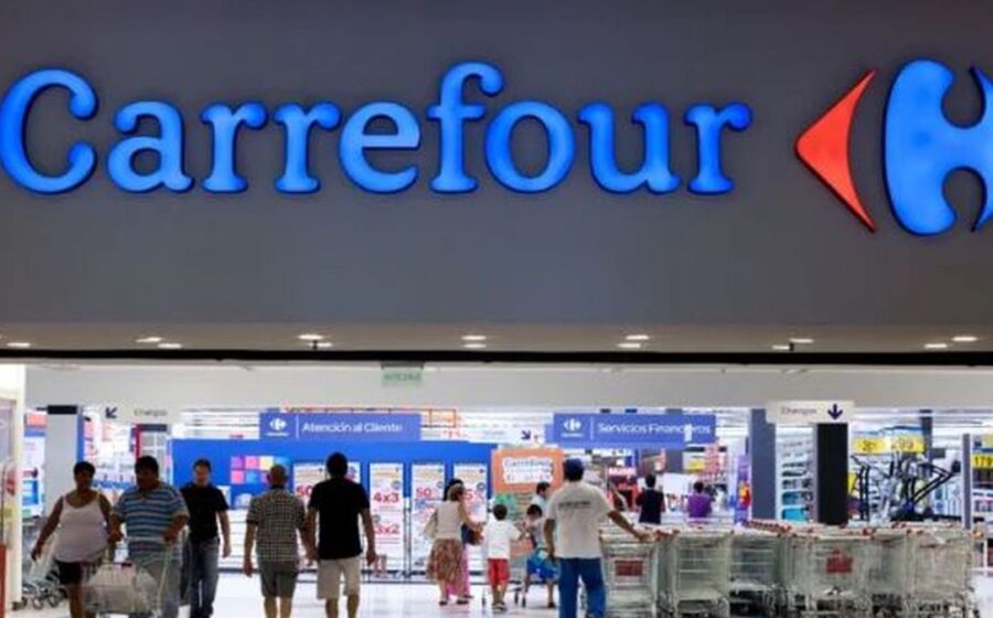 Fachada de loja Carrefour com placa de venda para Grupo Pereira