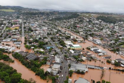 Alagamento em local de votação no Paraná com urnas eletrônicas e eleitores sob chuva forte