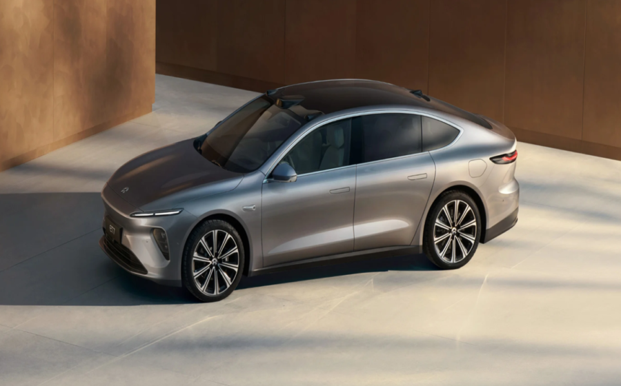 Logos da Nio e Geely sobre fundo de estações de recarga e troca de baterias para veículos elétricos