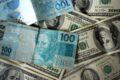 Gráfico mostra projeção do dólar entre R$ 4,90 e R$ 5,50 com urna eletrônica brasileira ao fundo