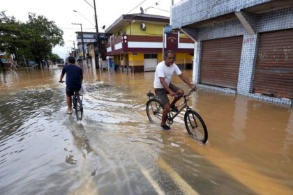 Escavadeira hidráulica sobre pontão flutuante dragando canal na Ponta do Lessa, Florianópolis