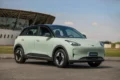 Logos da Nio e Geely unidos sobre fundo de estações de troca de baterias e carregadores elétricos na China