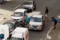Motorista de aplicativo com celular escondido no painel do carro em rua movimentada de São Paulo