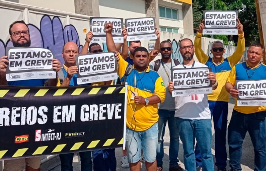 Trabalhadores dos Correios em greve com faixas e caixas de encomendas paradas em centro de distribuição