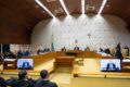 Funcionários da Caixa em greve diante de agência bancária com faixas e cartazes