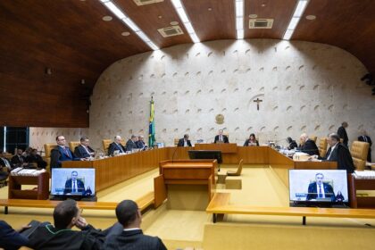 Funcionários da Caixa em greve diante de agência bancária com faixas e cartazes