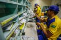 Bancários da Caixa em greve diante de agência com faixa de paralisação nacional