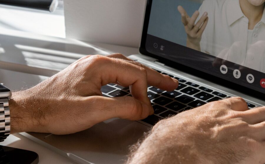 Ilustração de inteligência artificial traduzindo e-mail em notebook enquanto pessoa em reunião de negócios demonstra dificuldade de comunicação em inglês