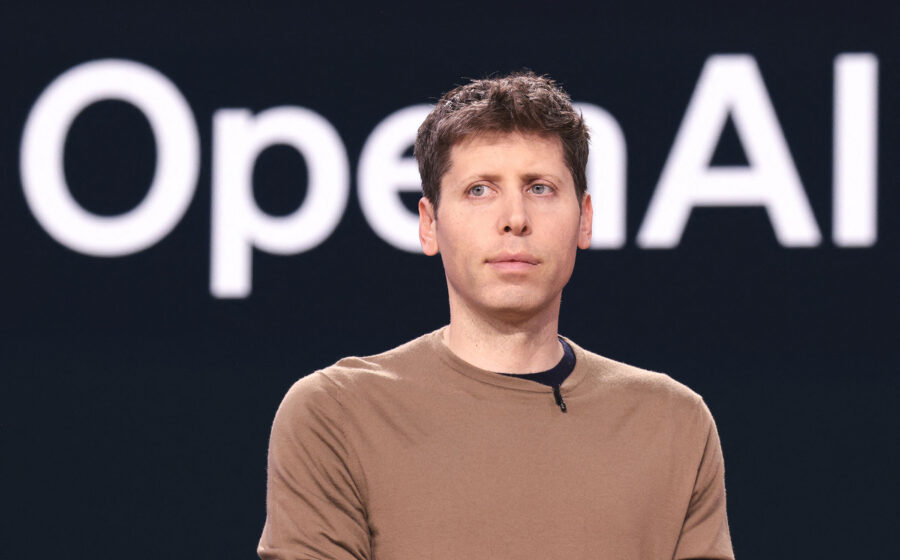 Sam Altman no palco da conferência da OpenAI com logotipo da empresa e gráfico de IPO parado