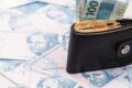 Casal com expressões contrastantes olhando gráfico de investimentos em queda no laptop