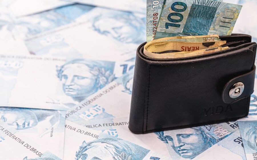 Casal com expressões contrastantes olhando gráfico de investimentos em queda no laptop