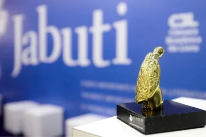 Troféu Jabuti dourado sobre mesa com 4.675 livros semifinalistas da 68ª edição
