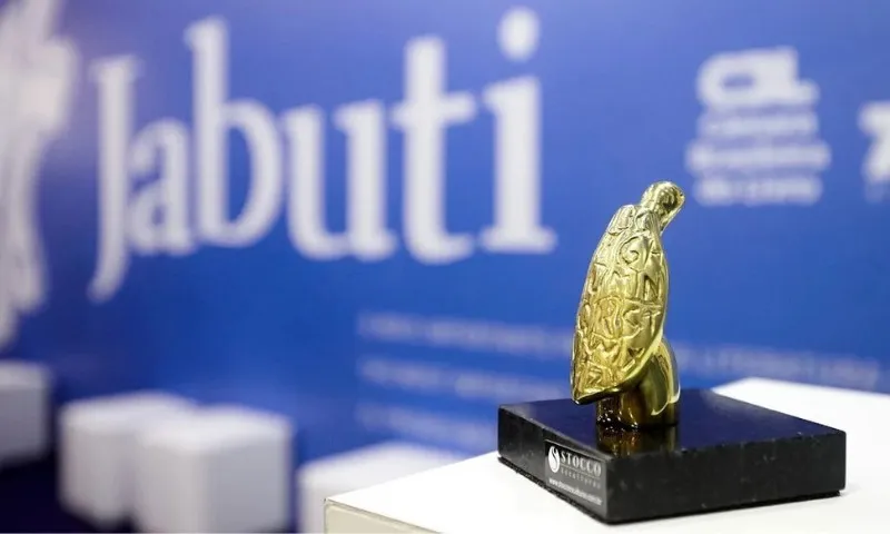 Troféu Jabuti dourado sobre mesa com 4.675 livros semifinalistas da 68ª edição