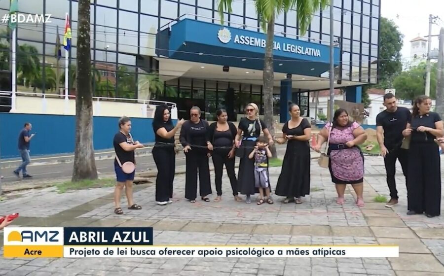 Mãe atípica abraça filho especial em Manaus com prédio da prefeitura ao fundo simbolizando lei sancionada com veto