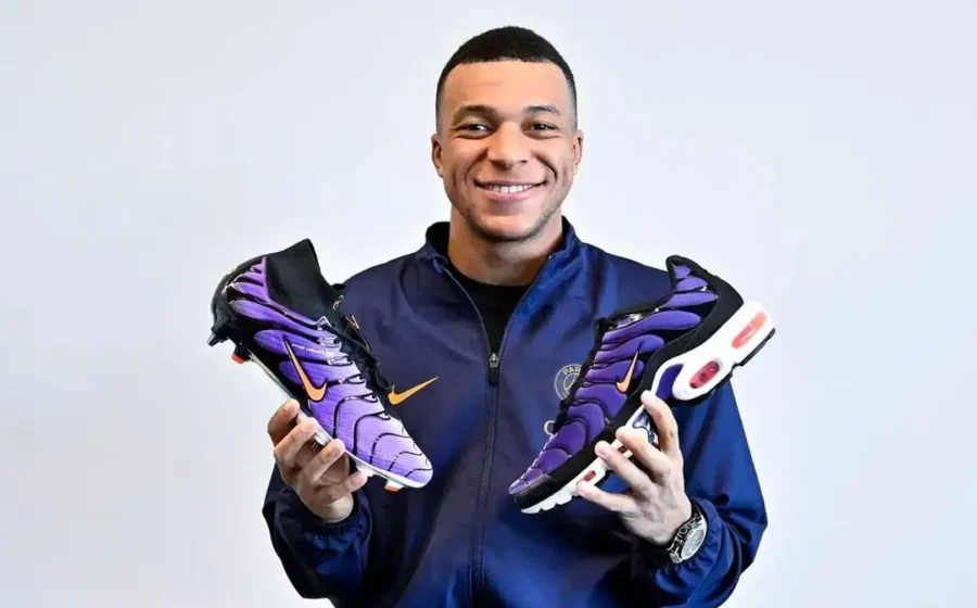 Kylian Mbappé vestindo uniforme da On assinando contrato, logo Nike riscado ao fundo