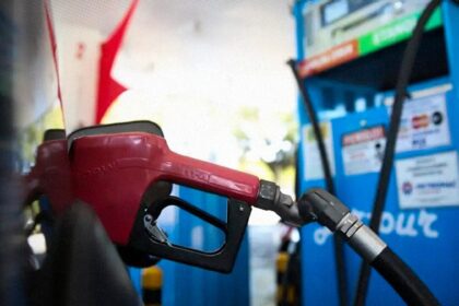 Posto de combustível com bomba de gasolina e placa de preço, representando fiscalização de preços abusivos