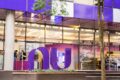 Gráfico de ações do Nubank em queda livre com ícone de fusão corporativa e bandeira do Reino Unido