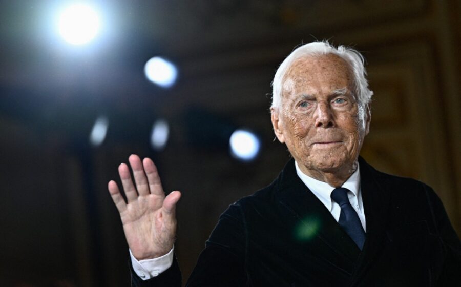 Giorgio Armani em seu ateliê cercado de esboços de moda, simbolizando legado e sucessão do império de US$ 8 bi