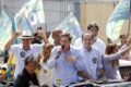 Santinhos de campanha jogados no chão em rua urbana na véspera da eleição, ilustrando crime eleitoral