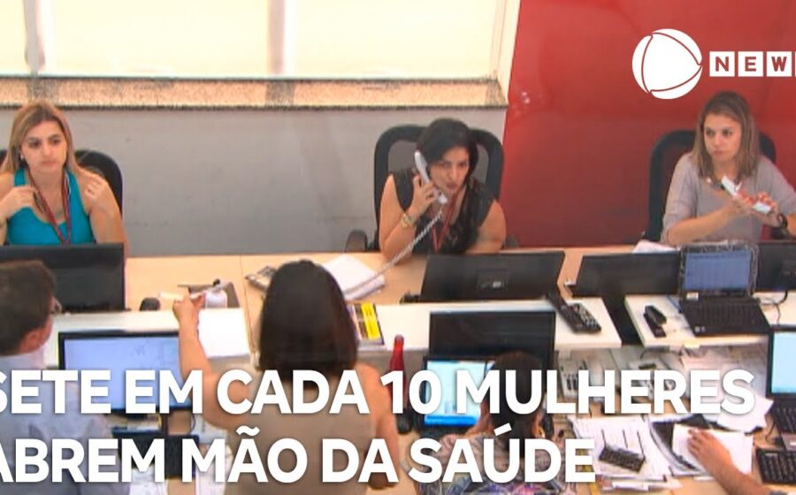 Mulheres em ponto de ônibus lotado olhando relógio, representando dificuldade de mobilidade urbana e impacto no emprego