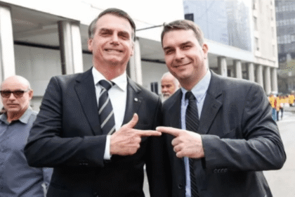 Aperto de mão entre bandeiras dos EUA e Brasil sob sombra de figuras políticas