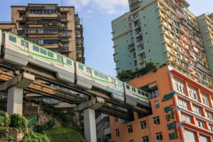 Metrô de Chongqing atravessando prédio residencial, símbolo da megacidade chinesa que conecta Ásia à Europa por ferrovia