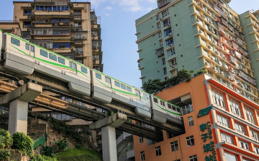 Metrô de Chongqing atravessando prédio residencial, símbolo da megacidade chinesa que conecta Ásia à Europa por ferrovia