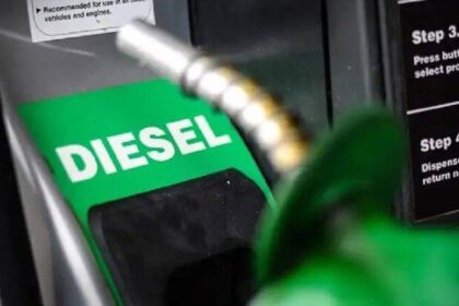 Bomba de combustível diesel com preço promocional de R$ 2,12 por litro e caminhão de carga ao fundo