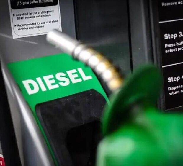 Bomba de combustível diesel com preço promocional de R$ 2,12 por litro e caminhão de carga ao fundo