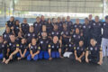 Mônica Mota, empreendedora, segurando camisa social adaptada para gestantes em fábrica de uniformes inclusivos