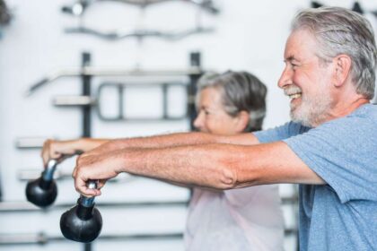 Carlos Roberto Castagini, 66 anos, e Lenita Capeli, 65 anos, treinando musculação pesada no interior de São Paulo, exemplificando longevidade produtiva e prevenção da sarcopenia