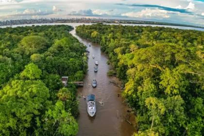 Barco do Projeto Alto Arapiuns atracado em comunidade ribeirinha do Pará com crianças sorrindo