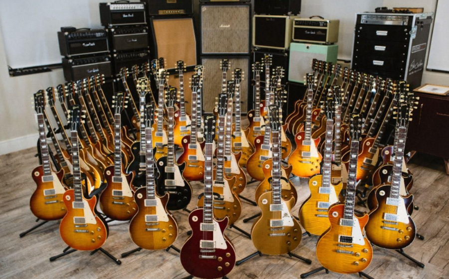 Cena do reality Duelo de Guitarras na TV Brasil: músicos com guitarras em casa-estúdio moderno