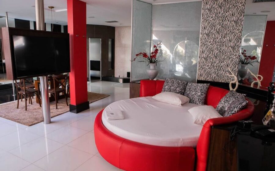 Suíte de motel de luxo em São Paulo com decoração sofisticada, cama king e amenities premium para estadia de lazer