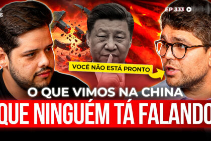 Executivos chineses e brasileiros apertando as mãos diante de fábrica com carros elétricos em linha de montagem