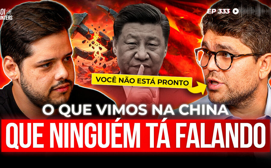 Executivos chineses e brasileiros apertando as mãos diante de fábrica com carros elétricos em linha de montagem
