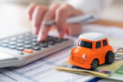 Carro zero-quilômetro em concessionária brasileira com calculadora e documentos de impostos sobre o capô