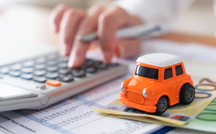 Carro zero-quilômetro em concessionária brasileira com calculadora e documentos de impostos sobre o capô