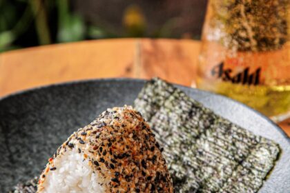 Onigiris triangulares embrulhados em alga nori prontos para delivery no litoral norte de SP