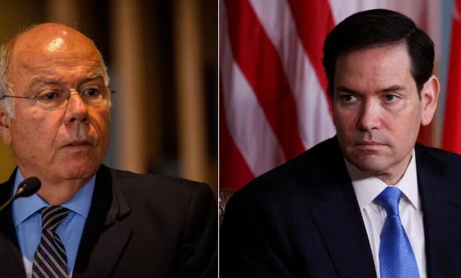 Marco Rubio em coletiva de imprensa, com bandeiras dos EUA e Brasil ao fundo, simbolizando tensão diplomática