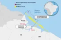 Vista aérea de Oiapoque no Amapá com barcos de pesca no rio e plataformas de petróleo ao fundo