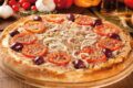 Pizza napolitana autêntica da Bento Pizzeria no prato, bordas altas e ingredientes frescos